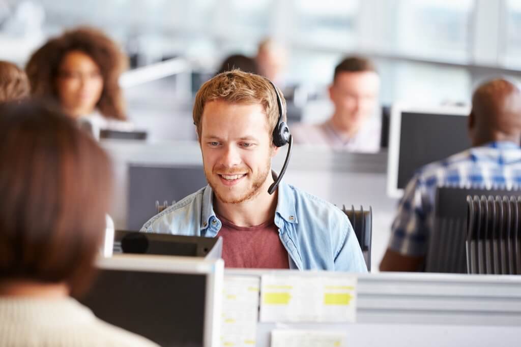 Young,Man,Working,At,A,Computer,In,A,Call,Centre